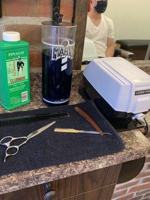 Warm shave cream dispensers, straight razors, Barbicide jars, and Clubman talc - the things a real barbershop should have.