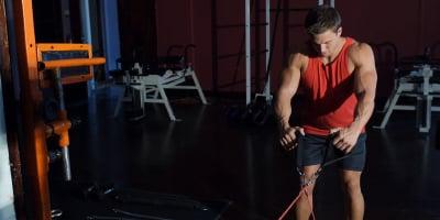 Kyle Ross using a doorway and wall gym 300 workout machine with elastic stress bands.