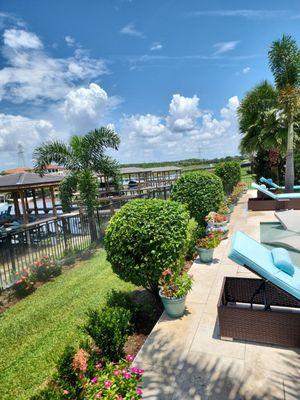 Waterfront and poolside landscape maintenance with manicured shrubs.