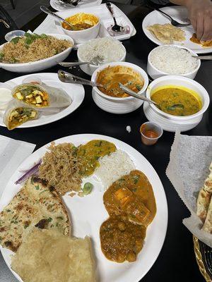 (From left to right) Fried rice, paneer tikka kati roll, chole, paneer tikka masala, yellow daal tadka. (On bottom) Garlic naan and bhatura