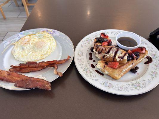 Berries and Cream Cheese French Toast. For the sides it's two eggs over easy and bacon