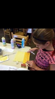 Stenciling flowers on a large tile