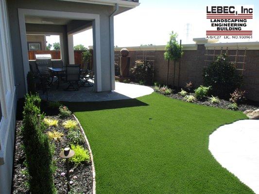 Blank canvas received two hand cut flagstone patios, custom BBQ and artificial turf with plantings around the house and along the fence