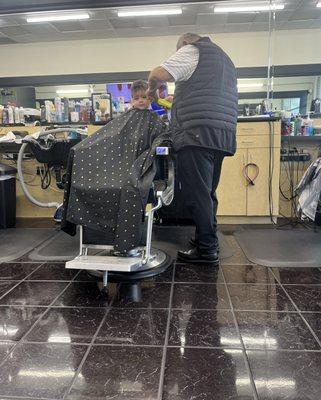 Arturo cutting my sons hair