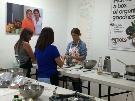 Nina, the instructor, showing students how to make dessert - cashew cream with blueberries