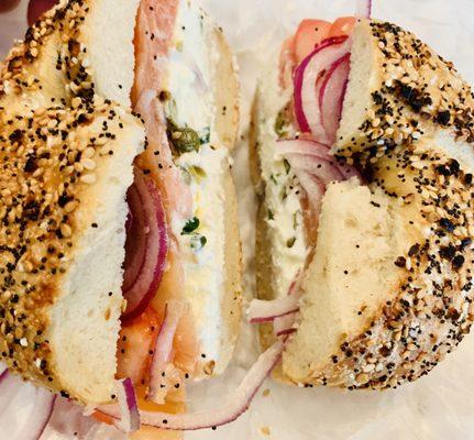 Everything bagel with lox, cream cheese, tomato, red onions, and capers