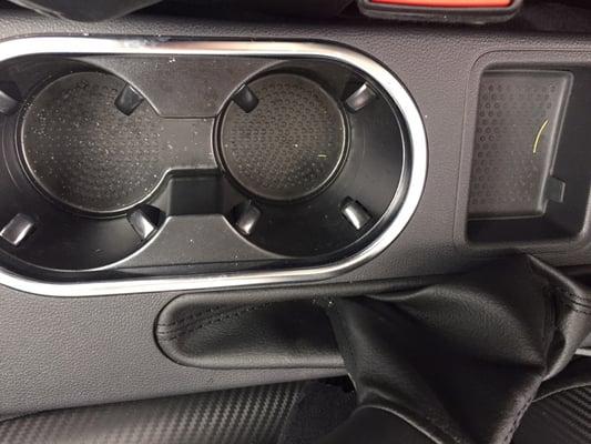 Filthy car: debris and rosemary/pine needle in cup holder.