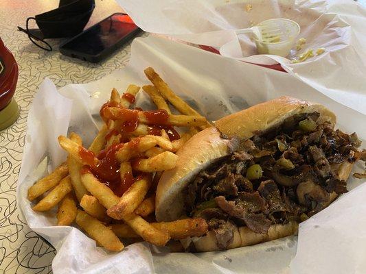 Original Philly Steak and cheese with peppers onions and mushrooms with a side of crispy french fries