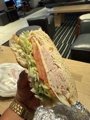 Turkey and cheese sandwich on a roll.