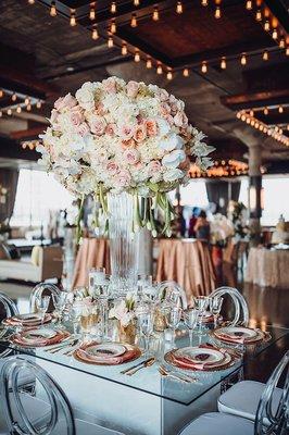 Wedding floral centerpiece on top of our custom led table with clear infinity chairs.