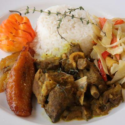 Curry goat whit rise steamed vegetables and sweet plantains