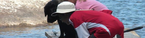 Guests enjoy that the cabins do not have TVs so that family time can be enjoyed. This photo is of a guest fishing with a lab named Lainey!