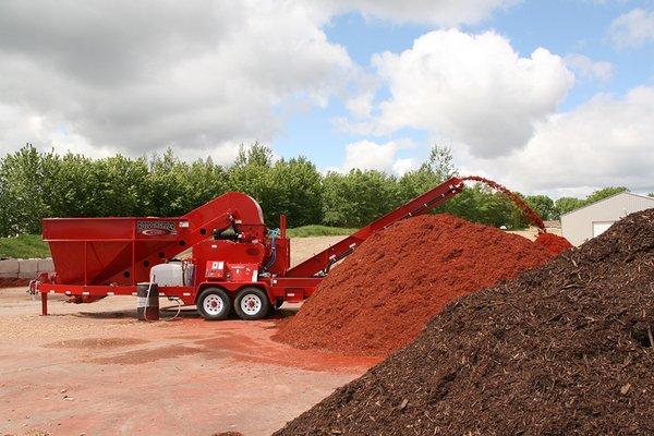 Making pretty mulch from the tree waste.  This keeps the trees out of the dump.  That would really be a waste of trees.