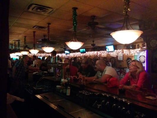 View from the ATM of the bar. Pool tables and darts. Ample seating, one booth and several tables bar height.