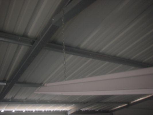 See the small chain holding the light on one side extended from the steel frame.