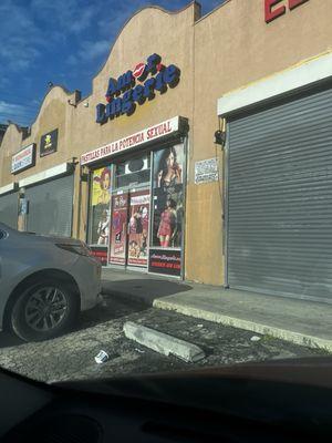 The outside of the shop.   There were beer cans and trash littered throughout the parking lot.