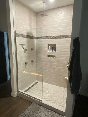 Custom Tile Shower with Delta Fixture, including rain head and body sprays with a trench drain