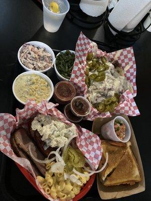 Chipotle slaw, spicy cream corn, green beans, brisket nachos, brisket Macncheese sandwich, brisket, jalapeño sausage, potato salad.