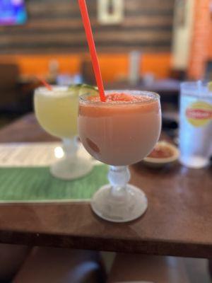 Strawberry margarita with sugar on the rim. With a margarita rocks behind.