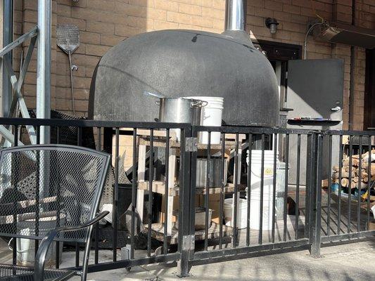 Kitchen mats, pots and pizza oven outside.