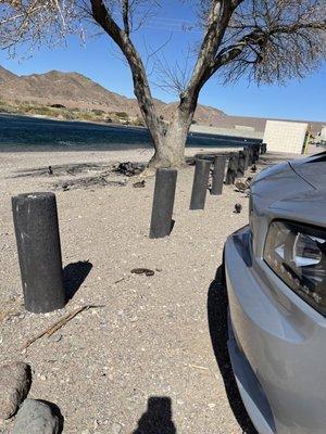 Parking area separated by posts from river. AZ side