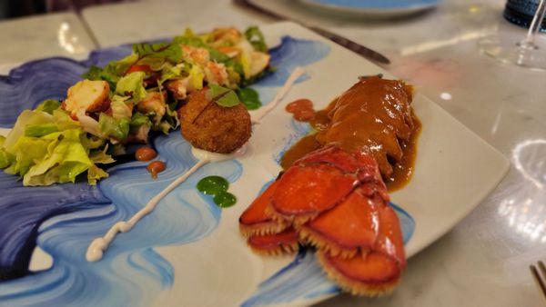 Lobster tail with lobster sauce a lobster croquette and lobster salad