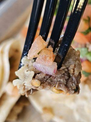 Close-up of a fork with a piece of the Flank Steak from the Traditional Flank Steak Taco.