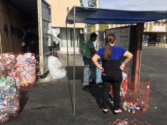 The guy in the green shirt weighs the material and operates the cash register.