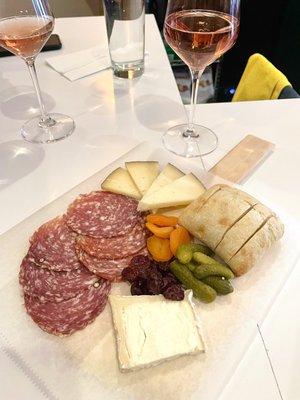 Charcuterie board with goat cheese, manchego, salami, bread, and accompaniments