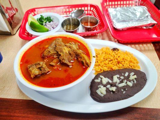 Birria De Chivo with black beans, rice and hand made tortillas.