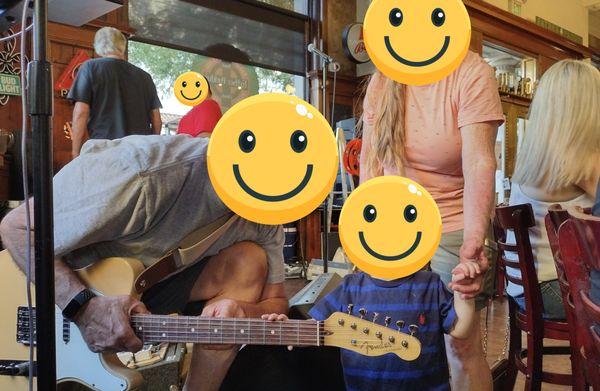 A toddler meeting a musician at Father Paddy's.