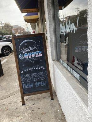 Sandwich board sign, "White Rock Coffee" in 80's rock ombré font.