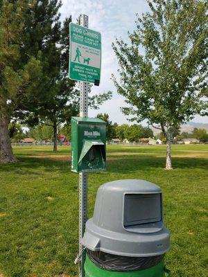 Mutt mitt and trash can at each corner of the park