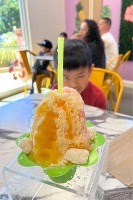 Regular shave ice with macupuno ice cream/ tiger's blood, mango, and passion fruit syrups/ Mochi and condensed milk topping