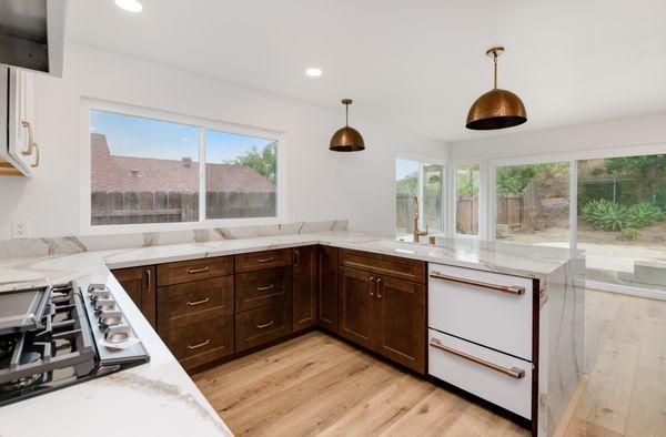 Elegant kitchen with high-end appliances and unique veining countertops.