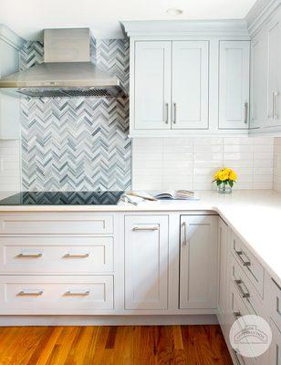 JM Construction's tiled backsplash adds subtle color accents to an otherwise white kitchen.