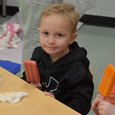 A boy holding a Popsicle.