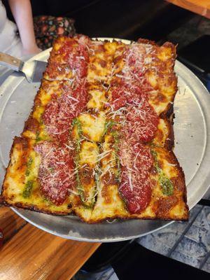 Detroit pizza half pesto, half  peperoni