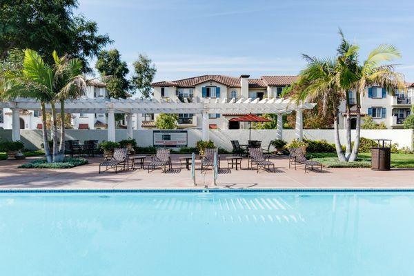 Swimming pool area with chairs and lounges.