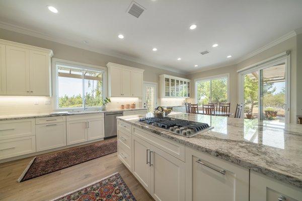 This kitchen remodel is ready for service! The recessed lighting, custom cabinets, new counters, and island fit in the open space perfectly.