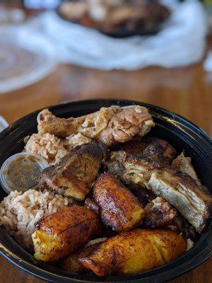 Jerk chicken and pork plate comes with fried plantains and rice and beans