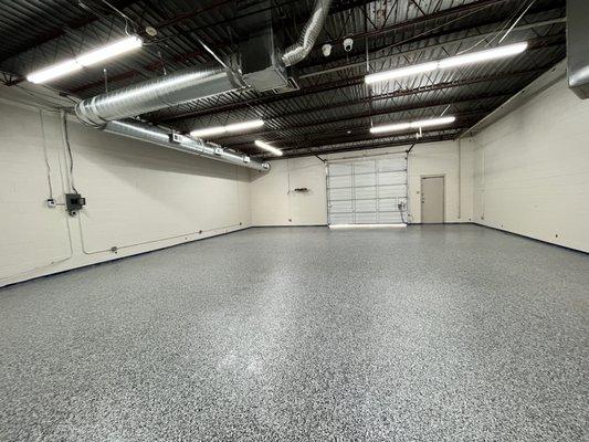 Flake Floor System: 100% epoxy base coat, Domino flakes, and polyaspartic protective topcoat.