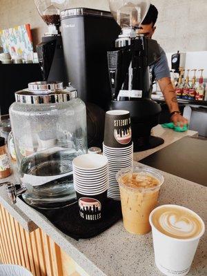 Iced vanilla latte & flat white. LOVE the water cups- so cool