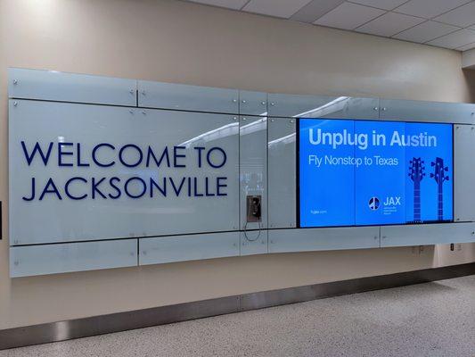 Welcome to Jacksonville sign near the rental car agency counters.