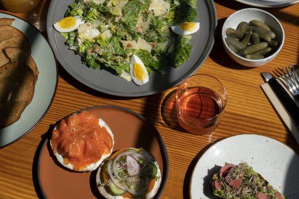 fresh salads, wine, bagels with lox and cream cheese