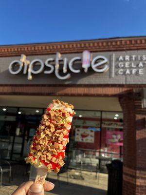 Strawberry Cheescake with strawberry syrup, pistachios, and waffle cone toppings!