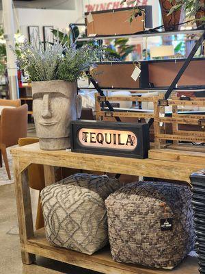 A display in the City Home showroom featuring a custom light-up sign, poofs, and a decorative planter.