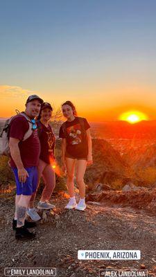 Family at the top of the hike with the sunset behind