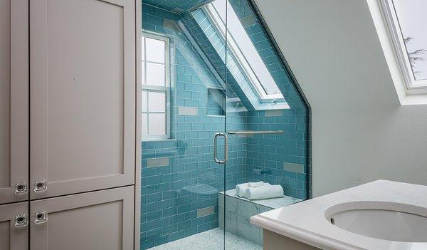 Beautiful frameless glass shower door with glass tile and skylight.