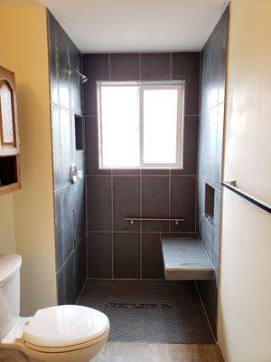 This is a walk in shower, it was built to fit the needs of the homeowner, reinforced bar and seat with hidden drain in the middle!